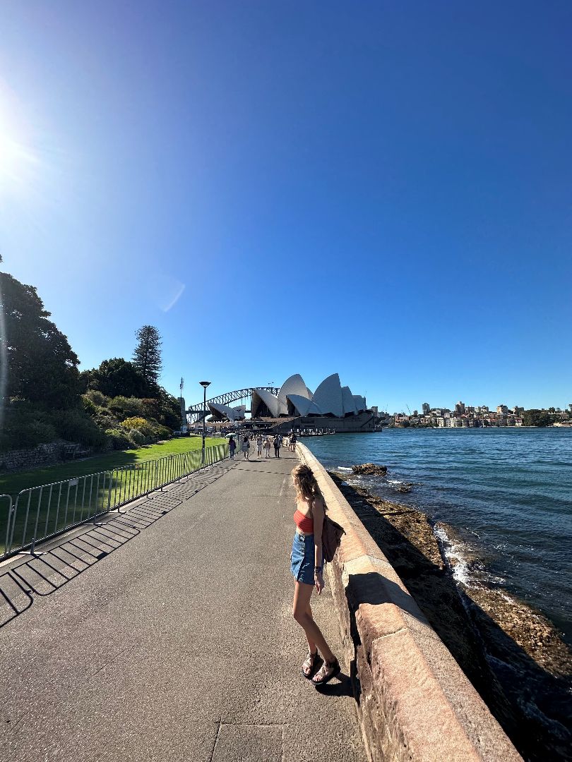 Cameryn on walkway along the harbor in Sydney with the Opera House in the distance
