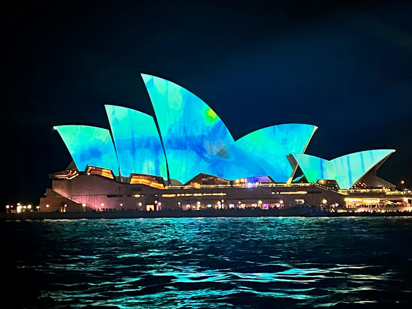 Bright green and blue lighting on the Opera House at night