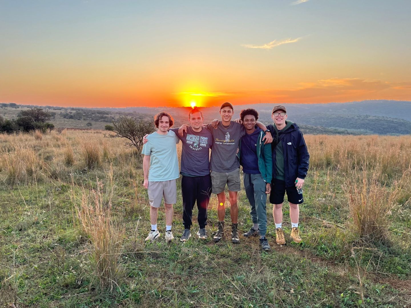 Kerem and freinds pose for a photo at sunset