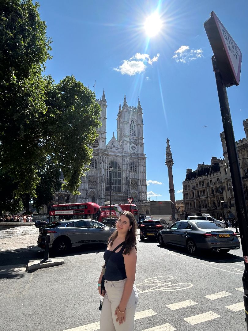 Alexandria standing in the streets of London with Westminster Abbey in the background