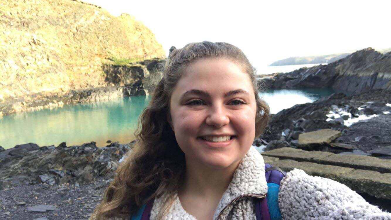 Maddie in front of a lake in the UK