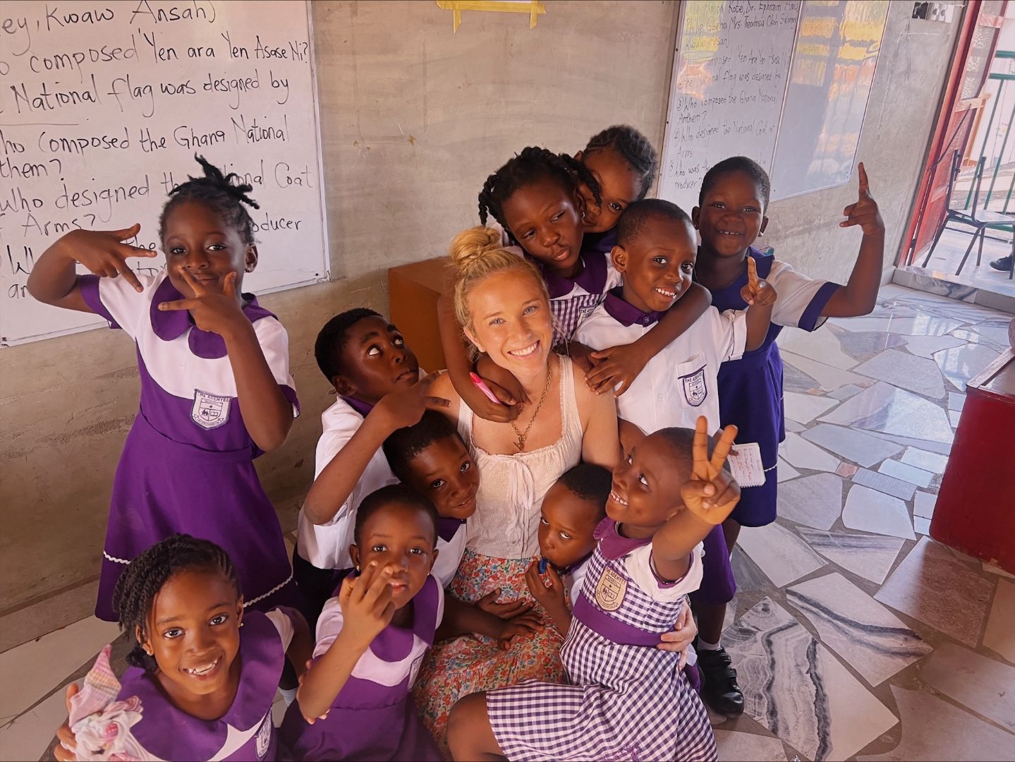 Kiara poses with local school children