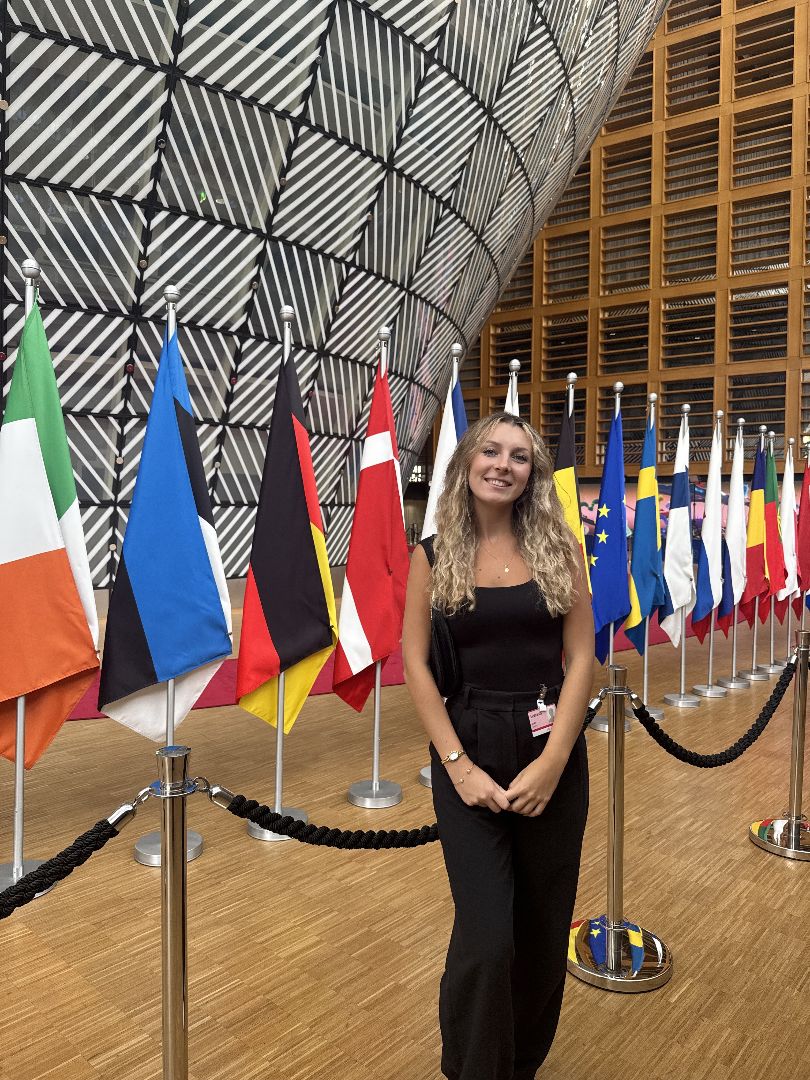 Yuliya standing in front of severl world flags in Belgium