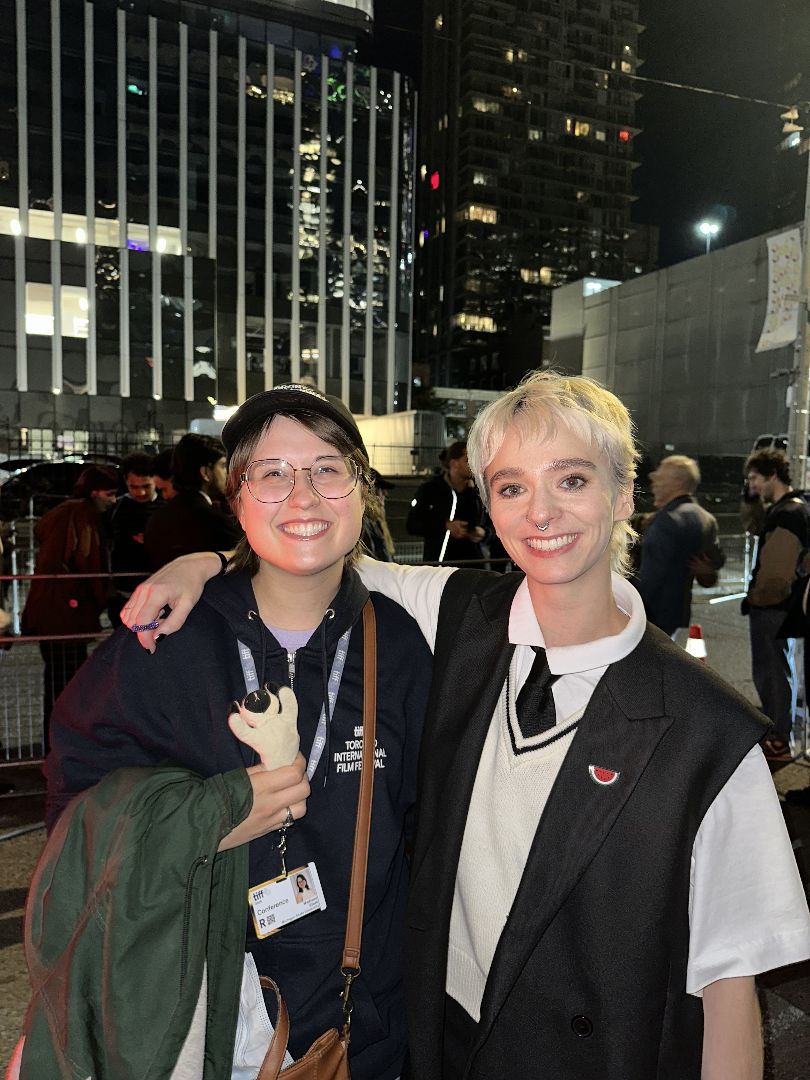 Madison stands with another woman in dowtown Toronto at night