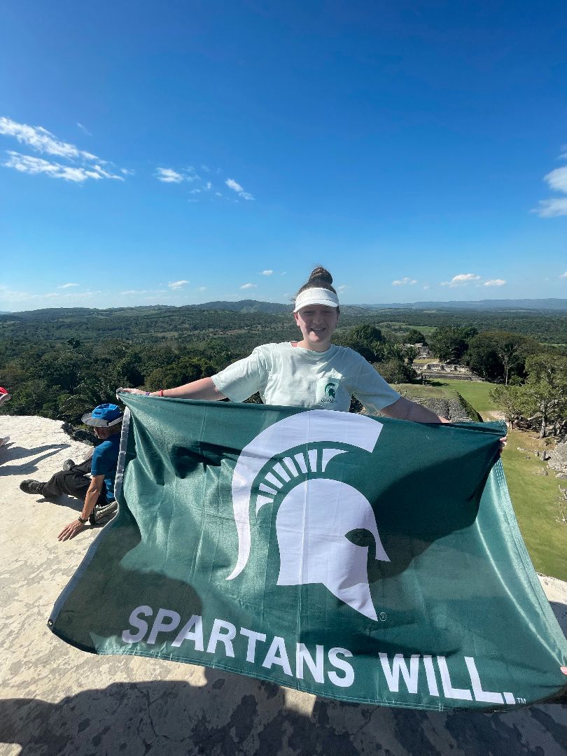 Summer holding Spartan flag atop Mayan ruins