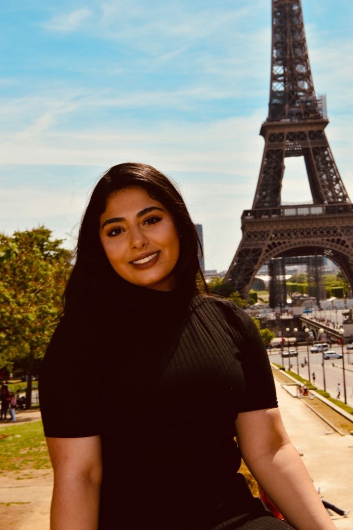 Zayna sitting in front of Eiffel Tower in Paris France