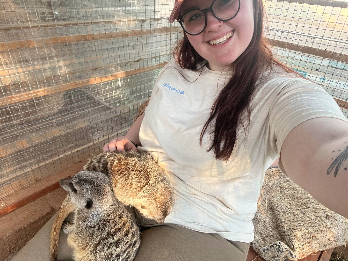 Kendall taking a selfie with two meerkats on her lap