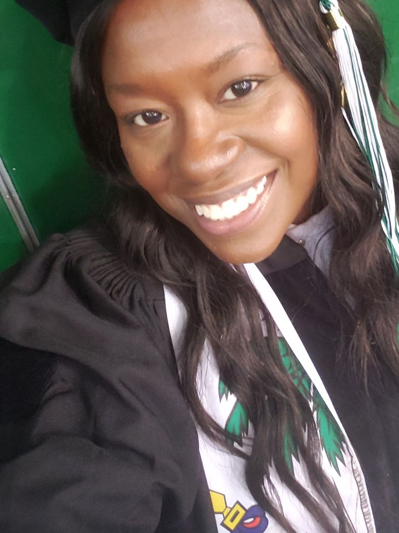 Dr. Shewonda Leger smiling facing camera. She is wearing a cap and gown