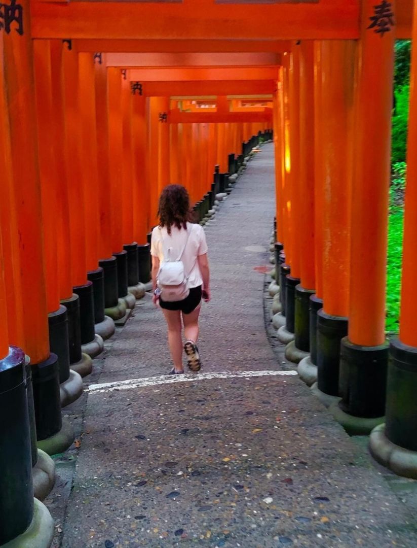 Cadence walking through a shrine with large orange pillars