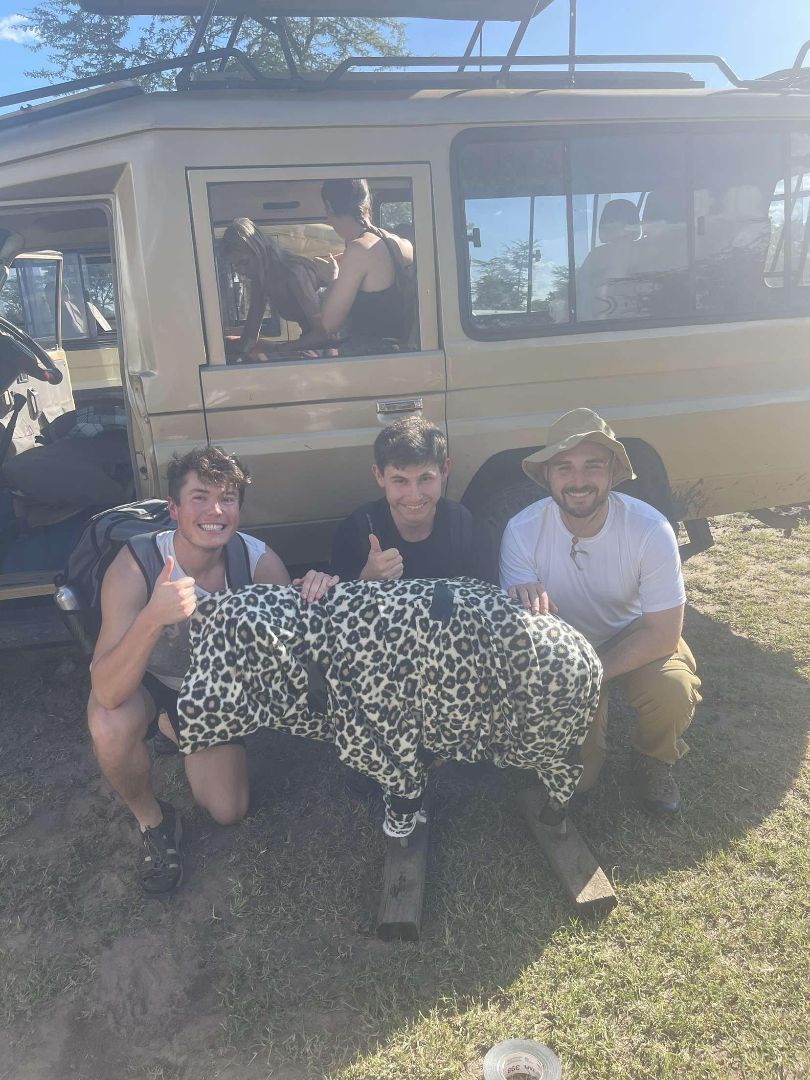 Ken with 2 other students posing with Cheetah target in Kenya