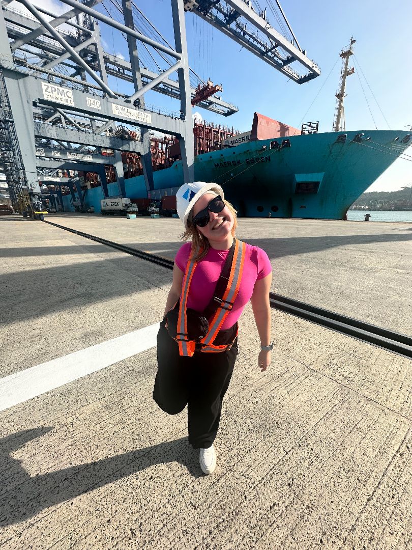 Abigain standing on the docks of the Panama Canal wearing a hardhat