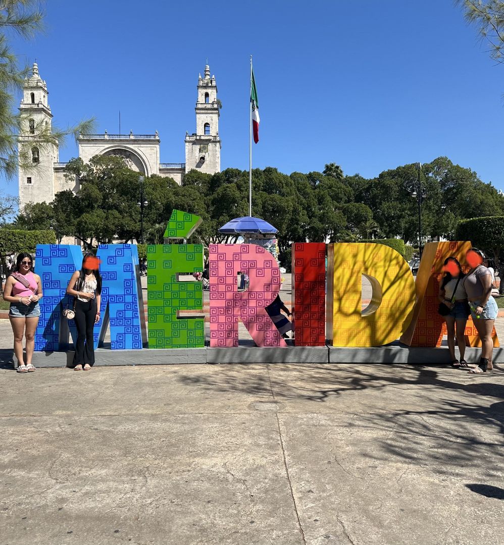 Students in front of colorful Merida sign in Mexico