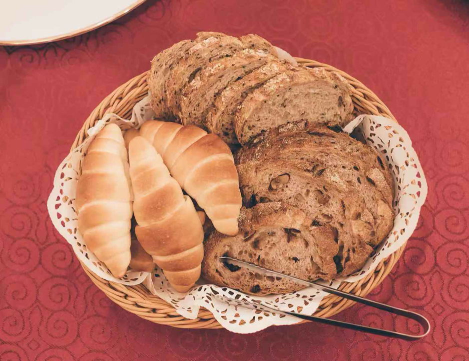 Close up image of the bread basket at the buffet table with crescent rolls and whole grain breads.