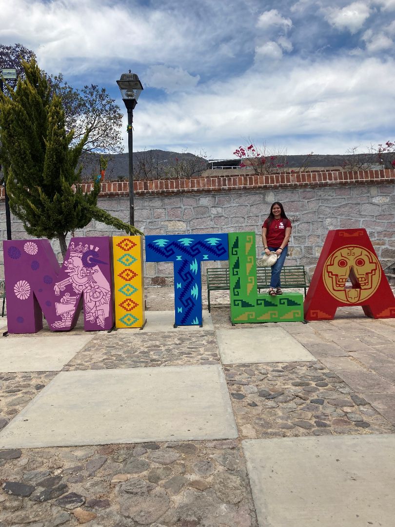 Luz standing on large letter L in Mexican town
