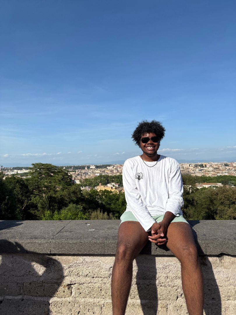 Sammy sitting on a stone wall overlooking Florence, Italy