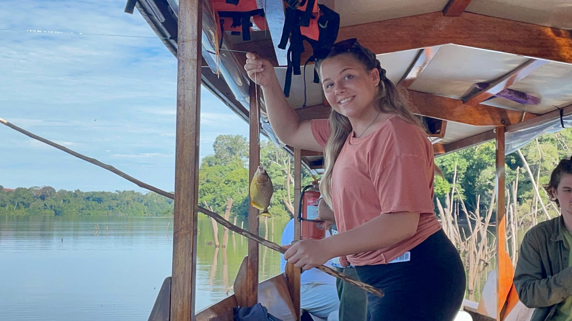 Anna standing in a covered river boat in Peru