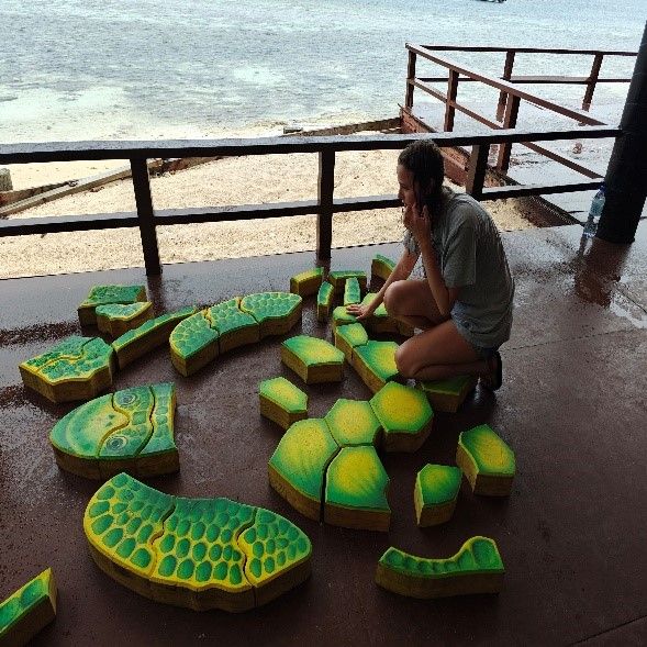 Erynn trying to put together a life-sized puzzle of a sea turtle