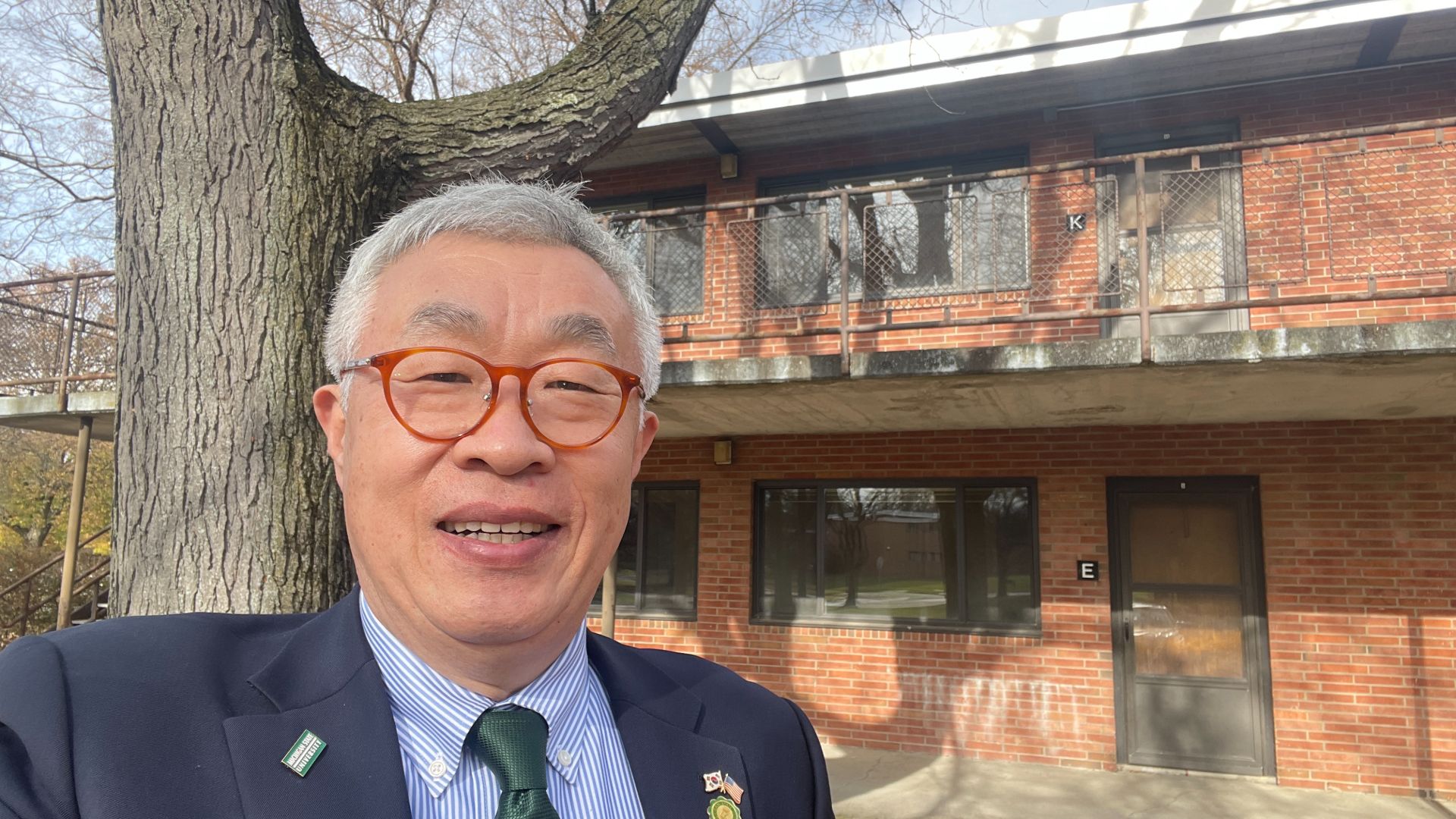 Chang stands outside his Spartan Village apartment