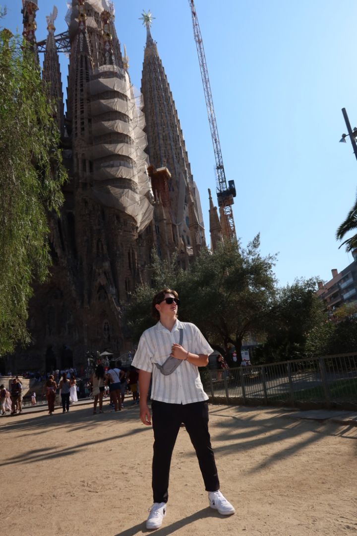 Adam wearing sunglasses and posing in front of the Sagrada Familia in Spain