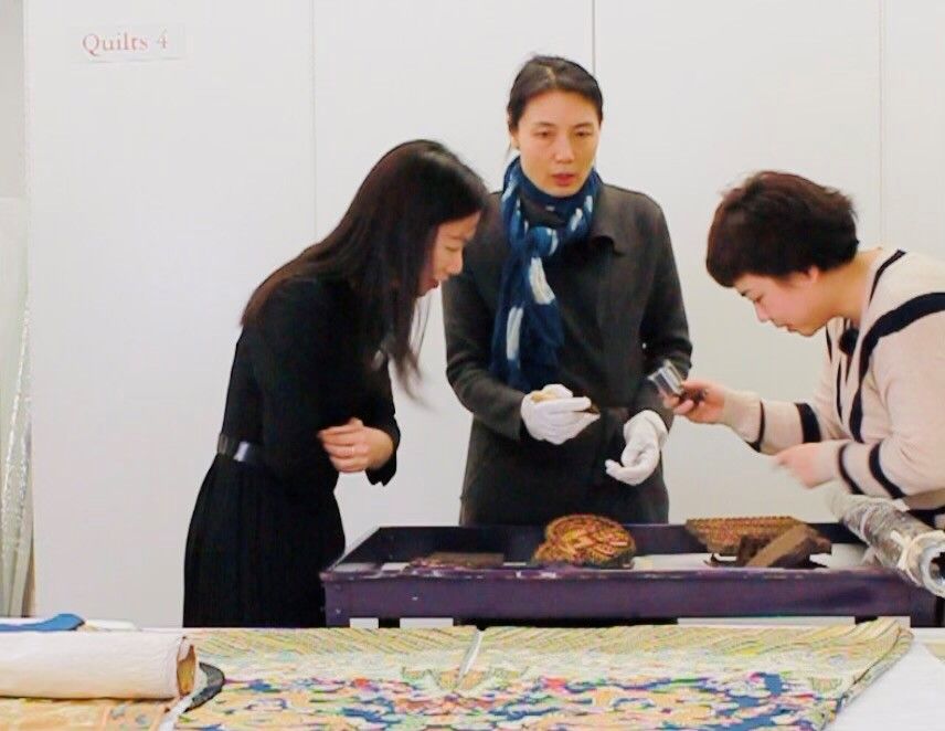 Luna Lu, Dr. Xia Gao, and Chenxue Huang viewing tapestry up close