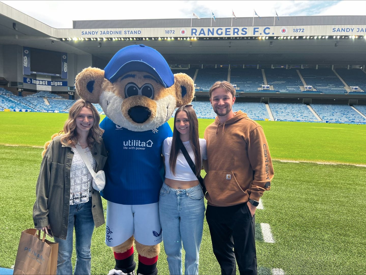 Jordan and friends posing with a bear mascot inside a soccer stadium in Ireland