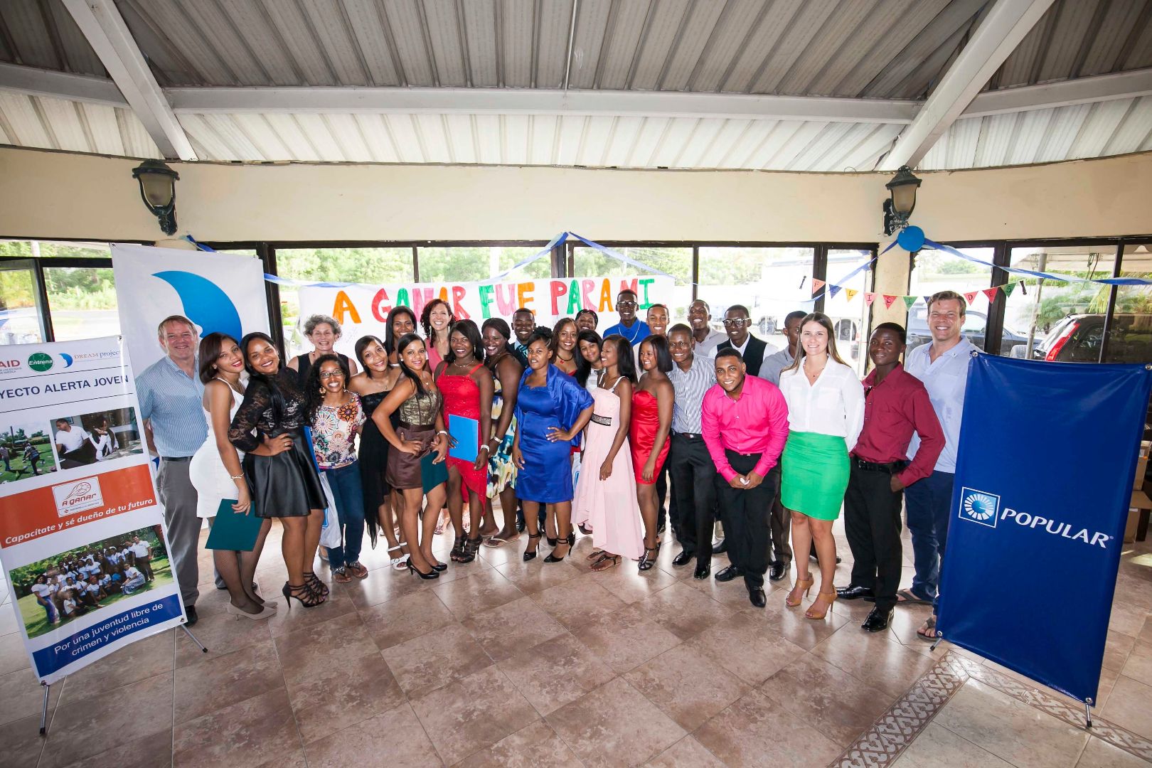 A large group of young leaders with the DREAM Project pose inside a building