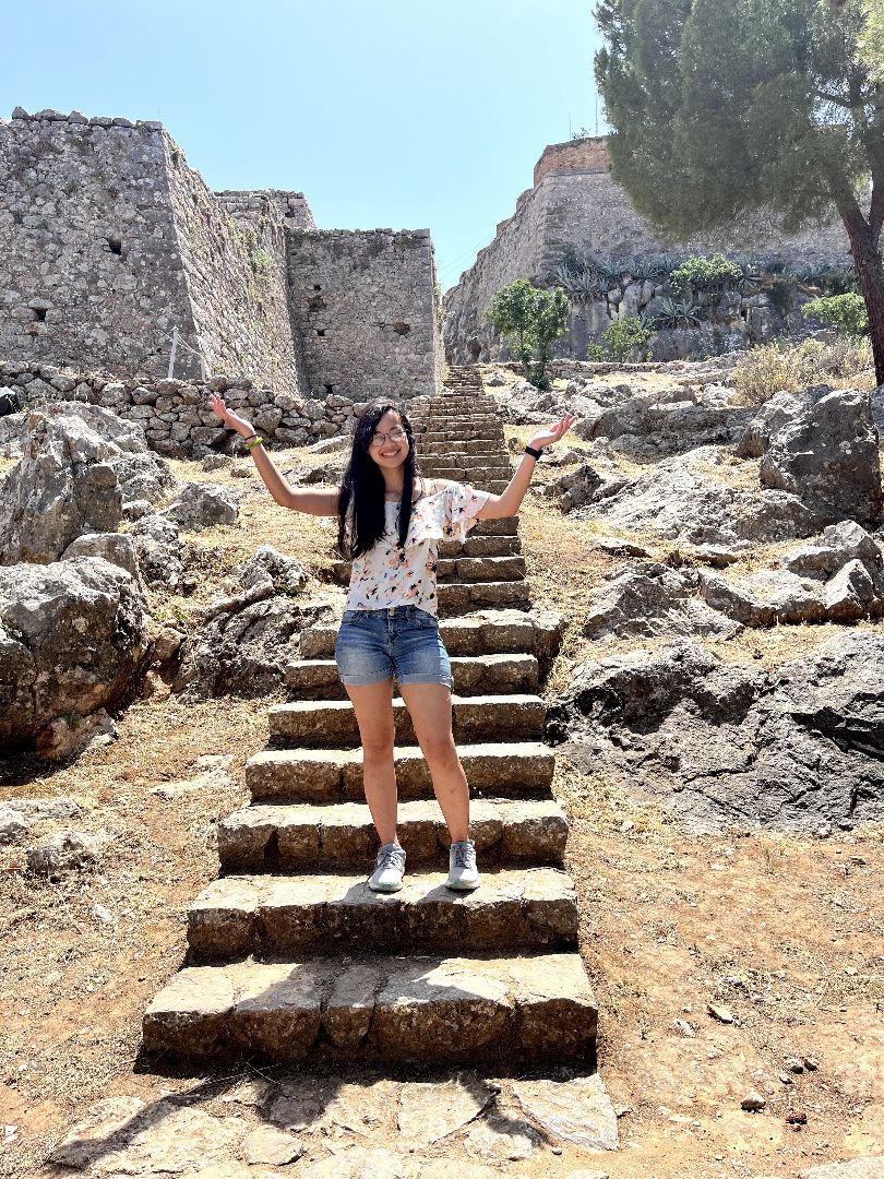 Kelly standing on steps of ruins in Greece