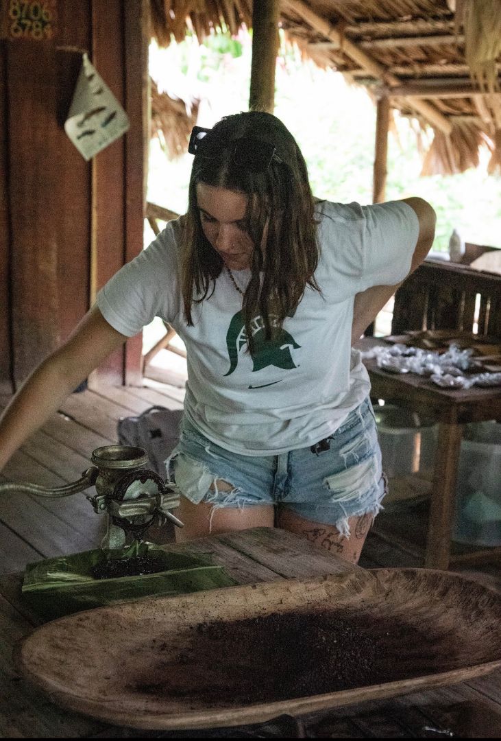 Delta wearing a Spartan tee shirt looking at an old grinder in Costa Rica