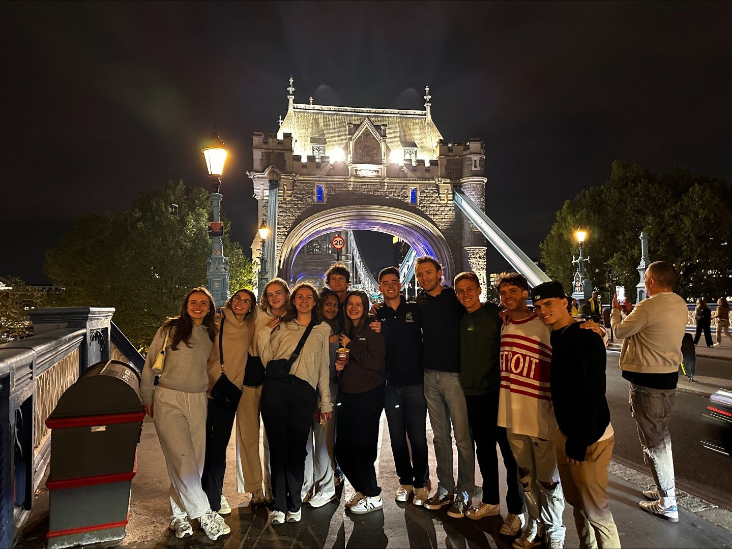 Group of students posing in front of Tower Bridge at night in London