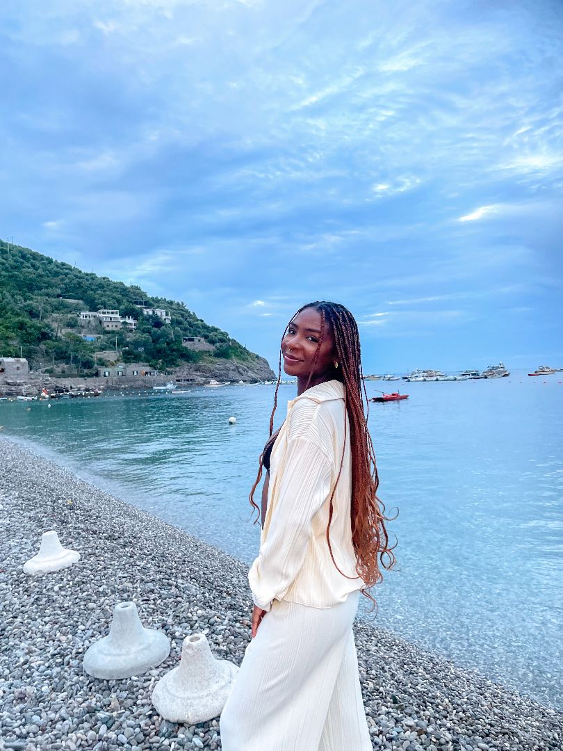 Kalila standing on rocky beach