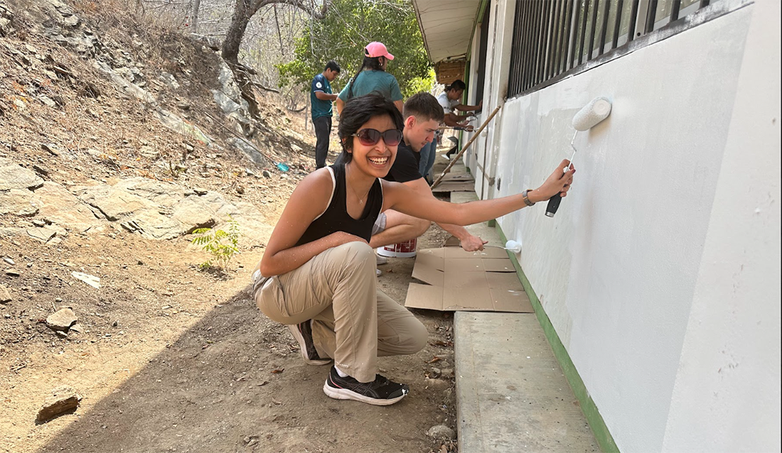 Veona Cutinho painting the exterior of a building