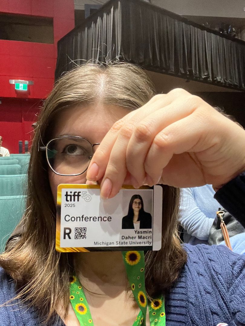 Yasmin holding her TIFF conference ID card