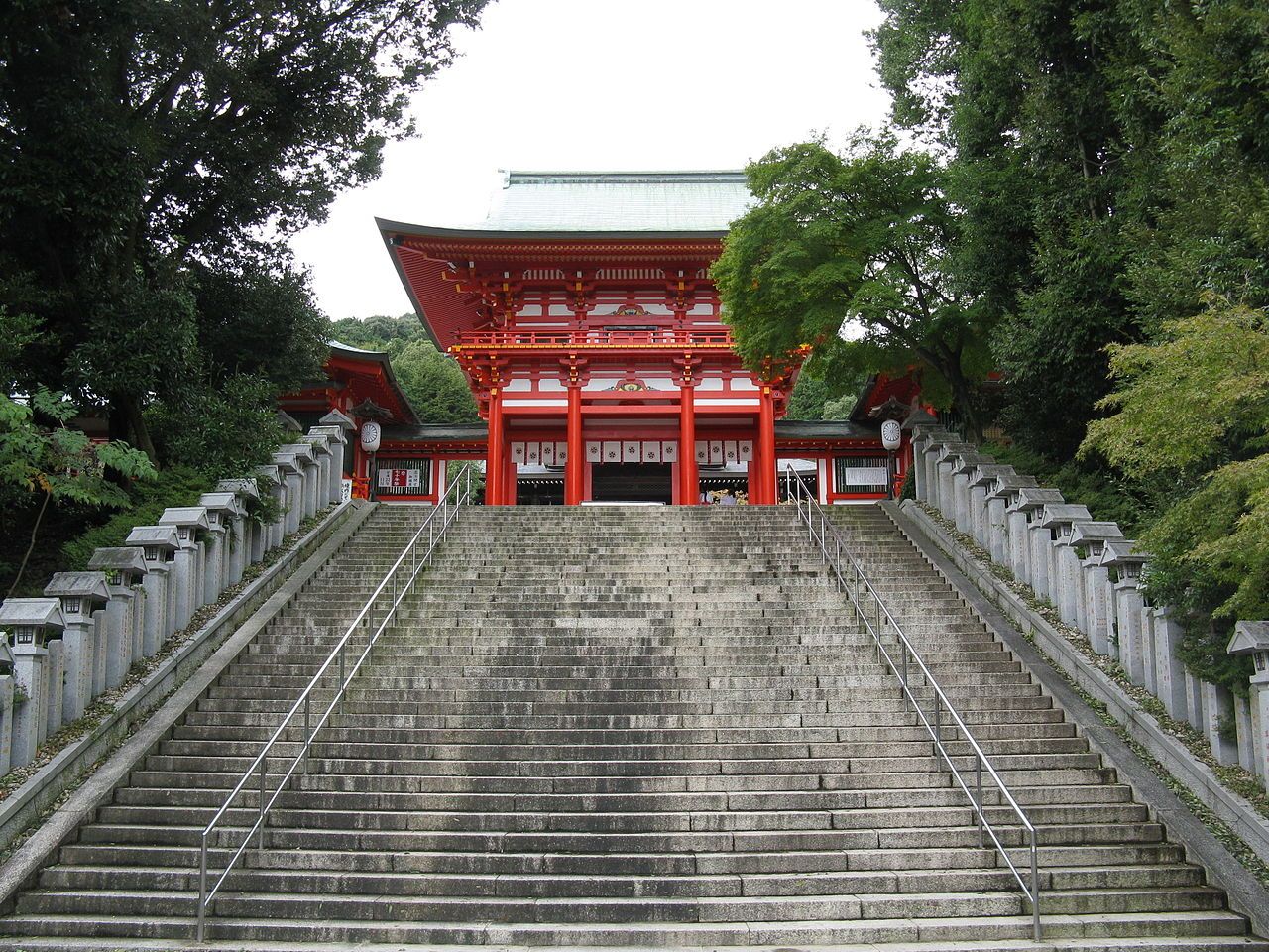 Large number of concrete stairs leading up to a shrine gate