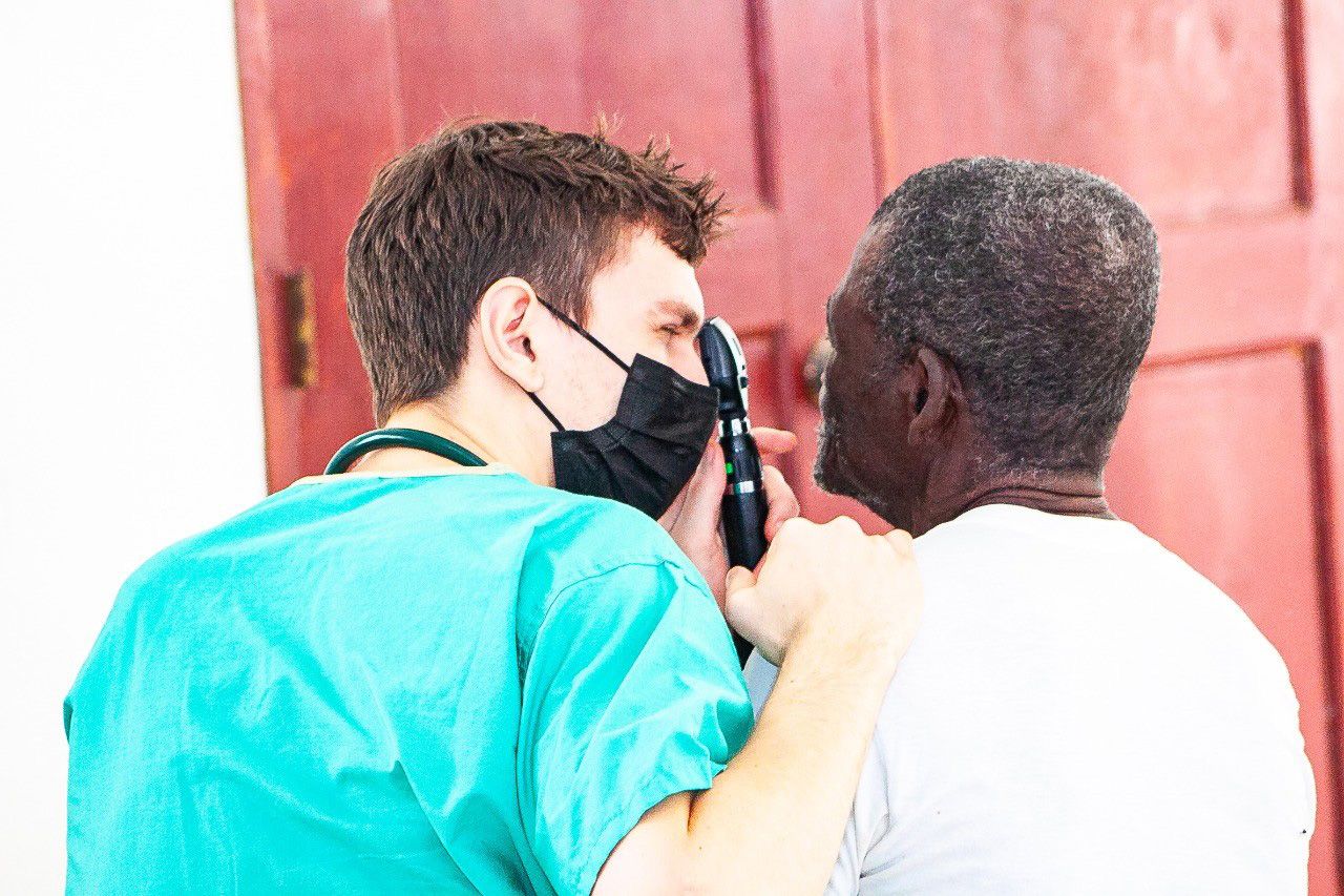 Benjamin examing a patients eyes in the Dominican Republic