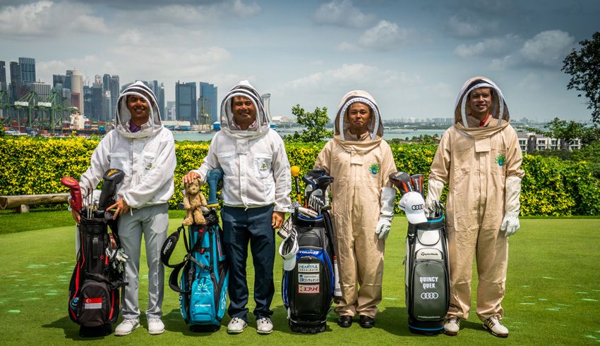 Beekeepers standing with golf equipment.