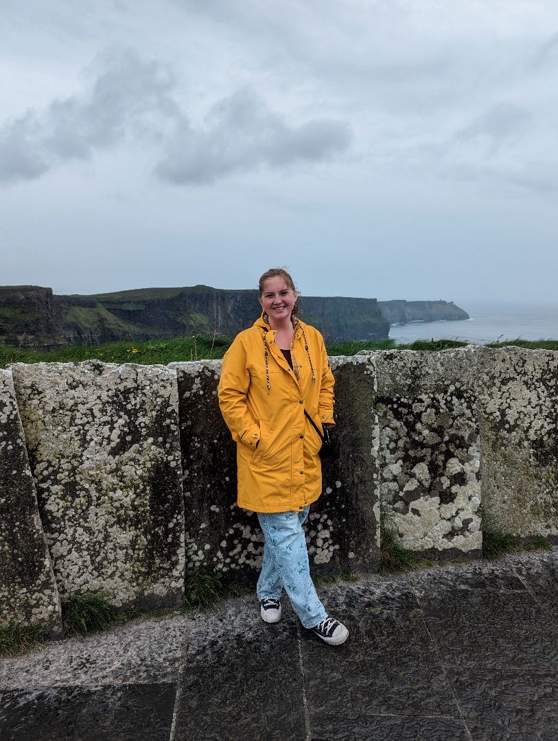 Sophie standing near the Cliffs of Moher in Ireland