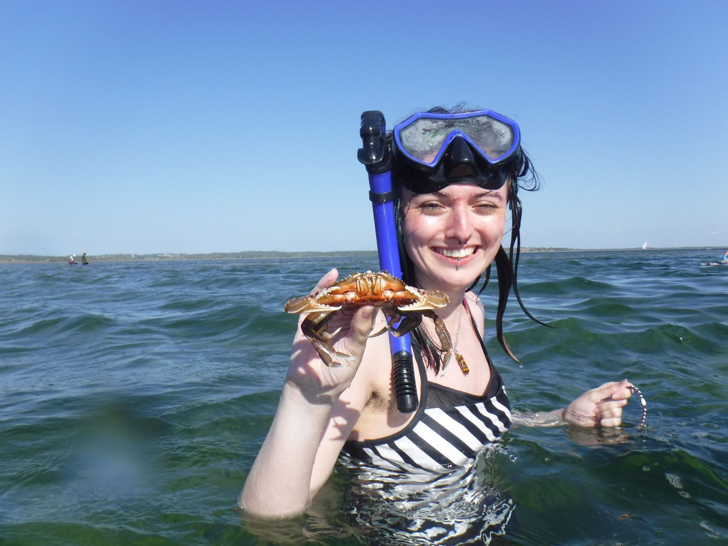 MaKenzie holding a crab while snorkeling in ocean