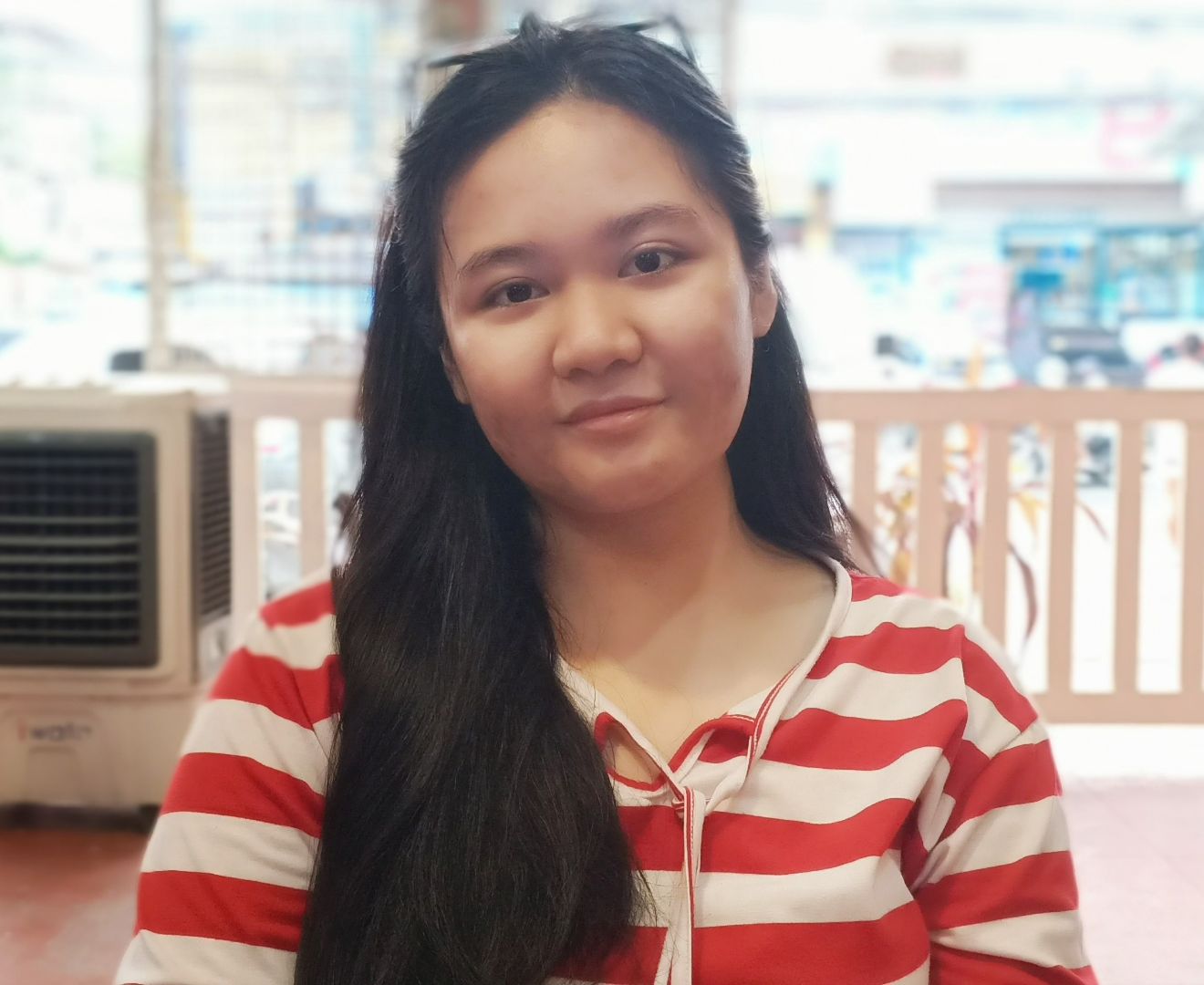 Krizzy Hazel S. Abringe, a 16 year old girl from the Philippines, slightly smiles at the camera for a portrait