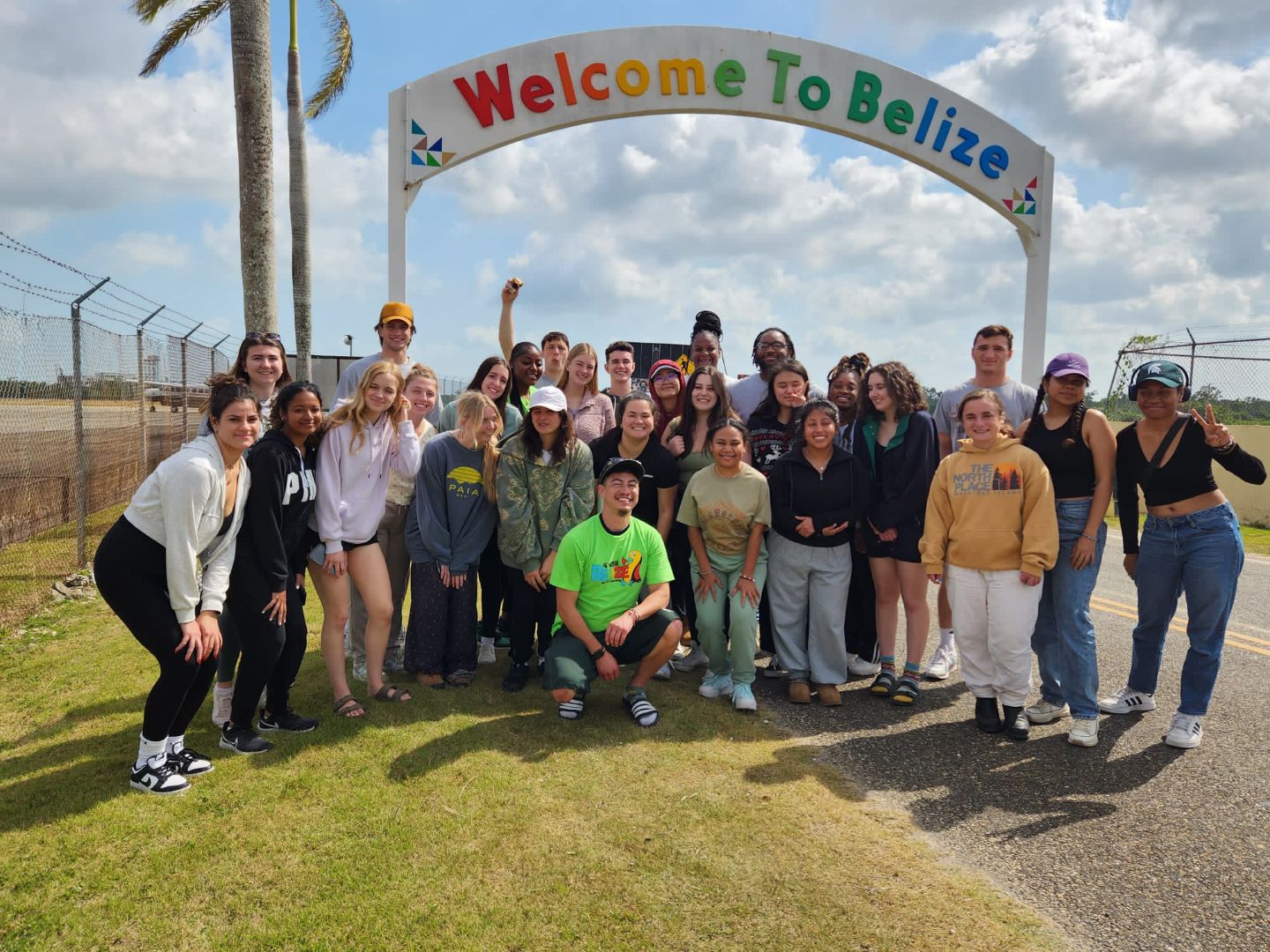 Group of MSU students standing under a sign that reads Welcome to Belize