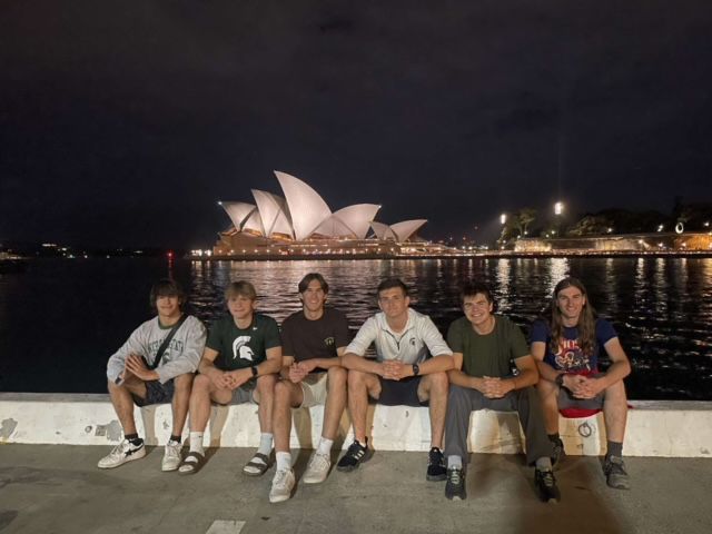 Gavyn and friends sitting on wall at night with Sydney Opera House in the background