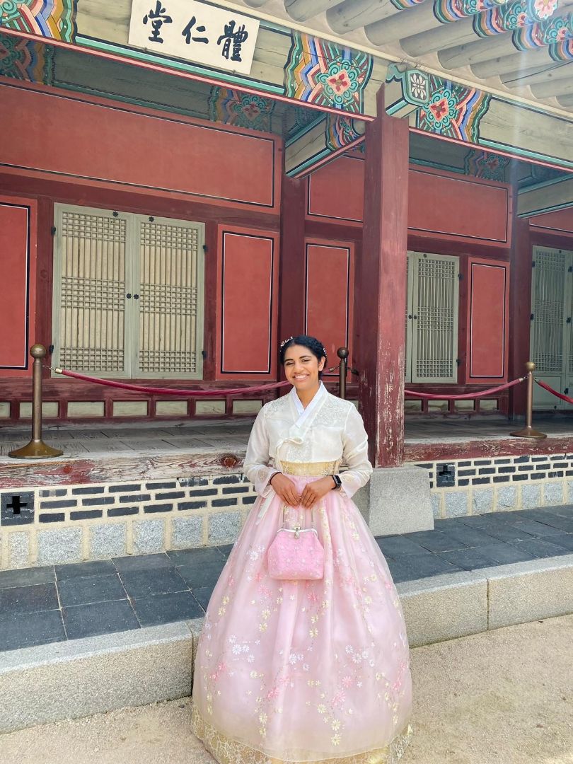 Viji standing in front of temple in Korean dress