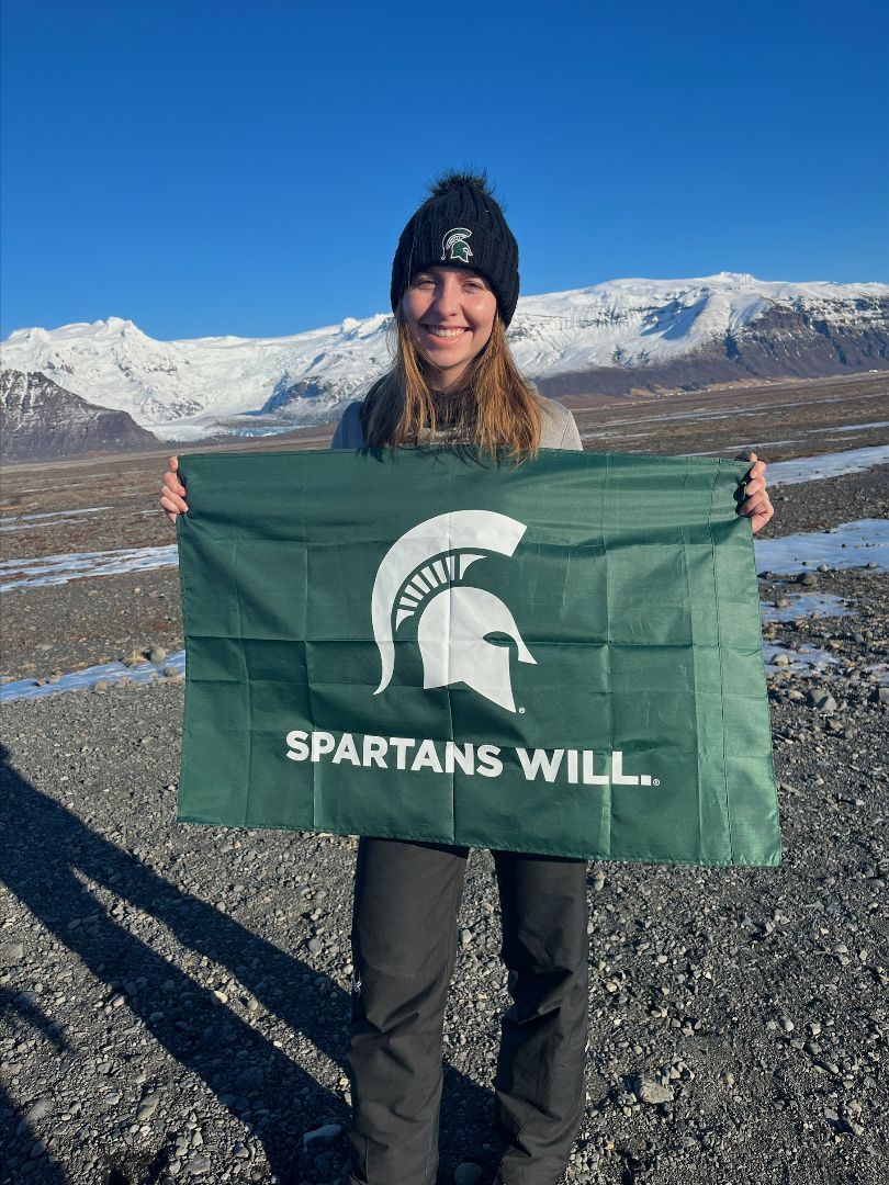 Anna holding a Spartan flag in Iceland