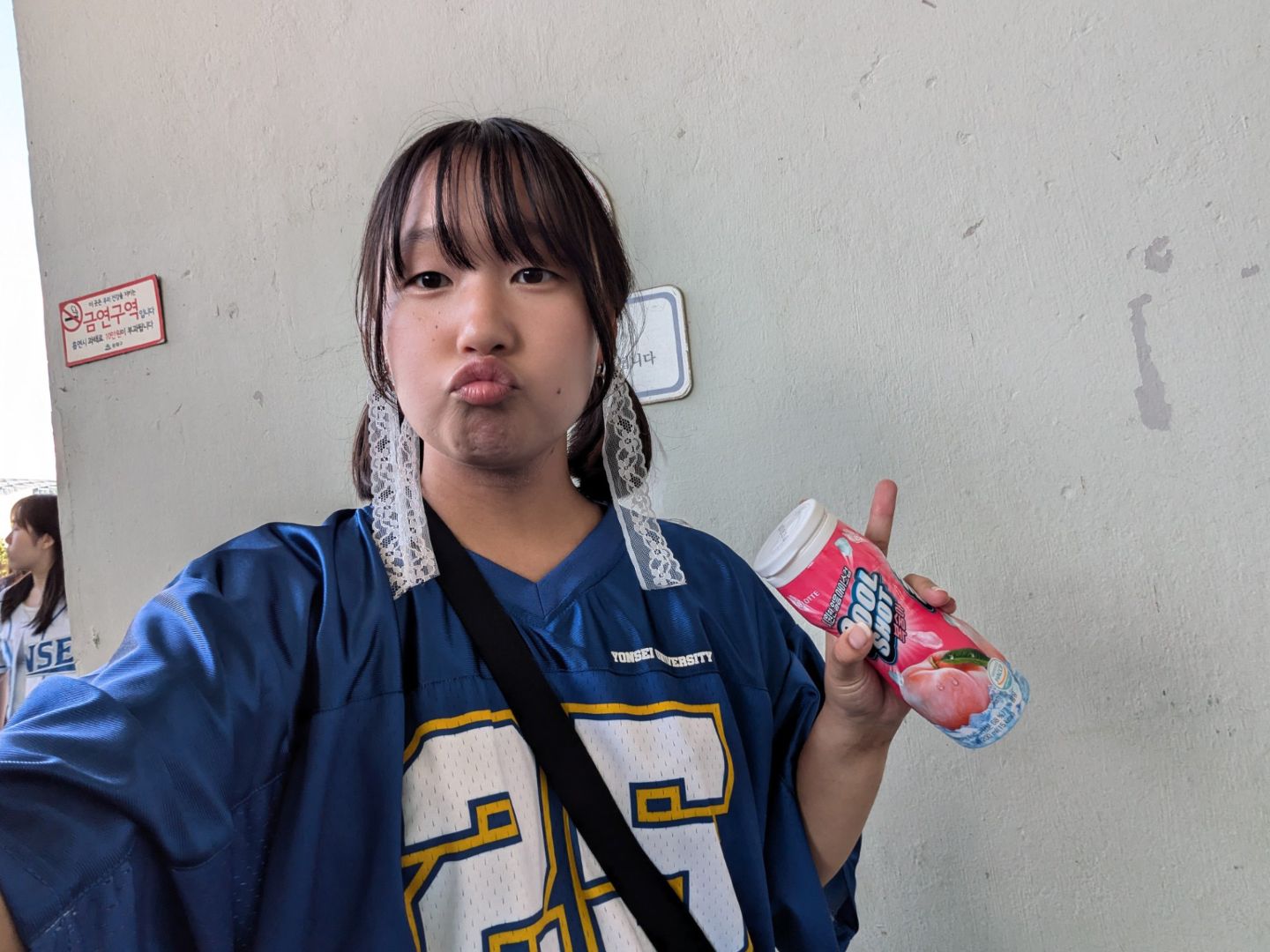 Alissa wearing a blue jersey holding a soda can