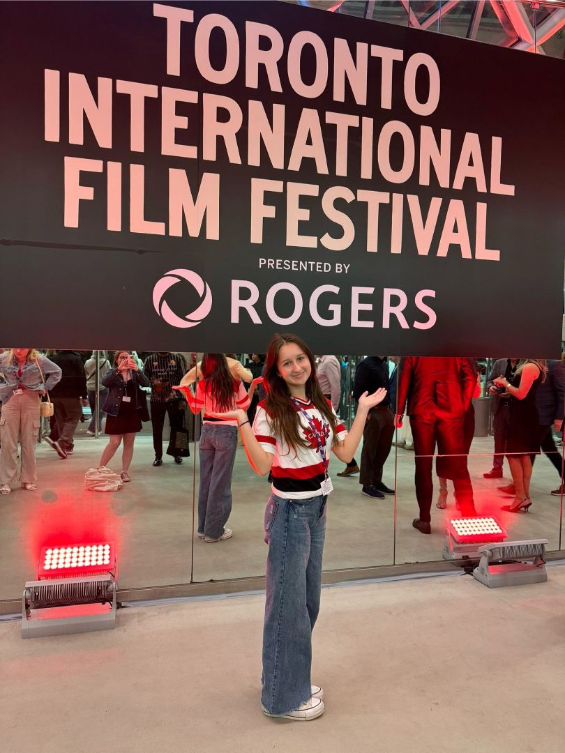 Klaudia standing in front of a sign that says Toronto International Film Festival