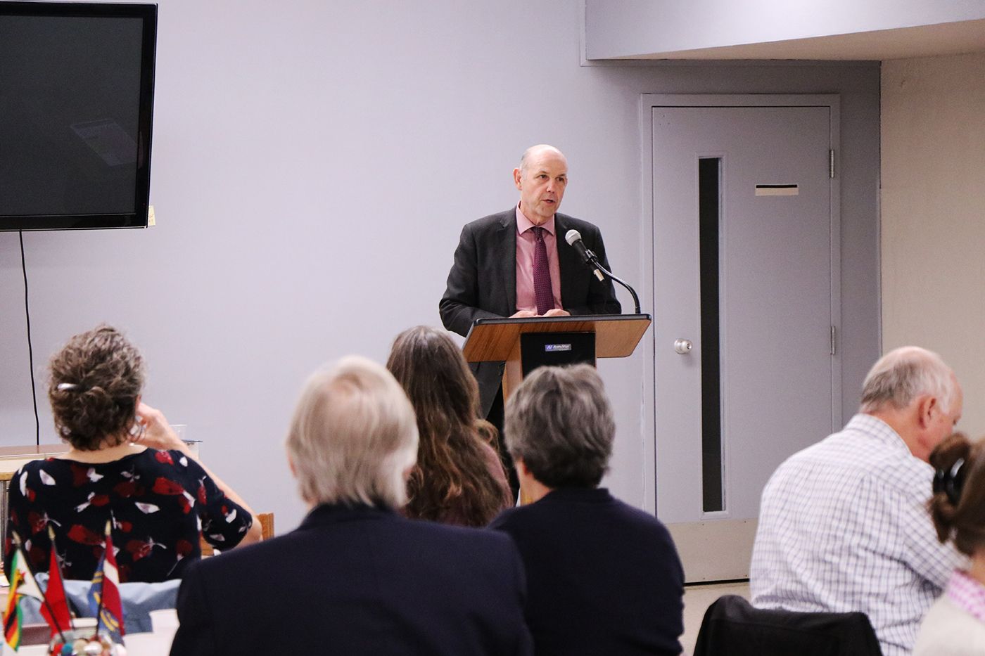 Dean Steven Hanson speaking to audience at CVIP luncheon. He is standing at the podium in front of the room.