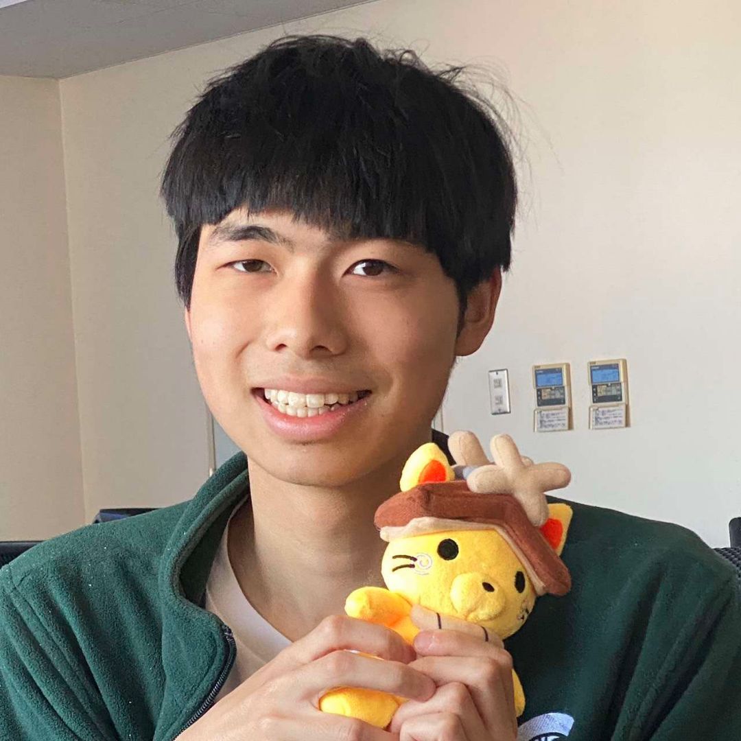 Alexander holding a Shimanekko, the mascot of Shimane, Japan