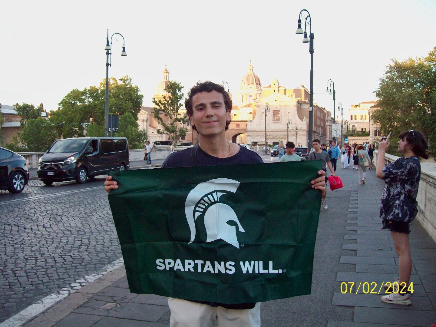 Alberto holding a Spartan flag on the streets of Rome