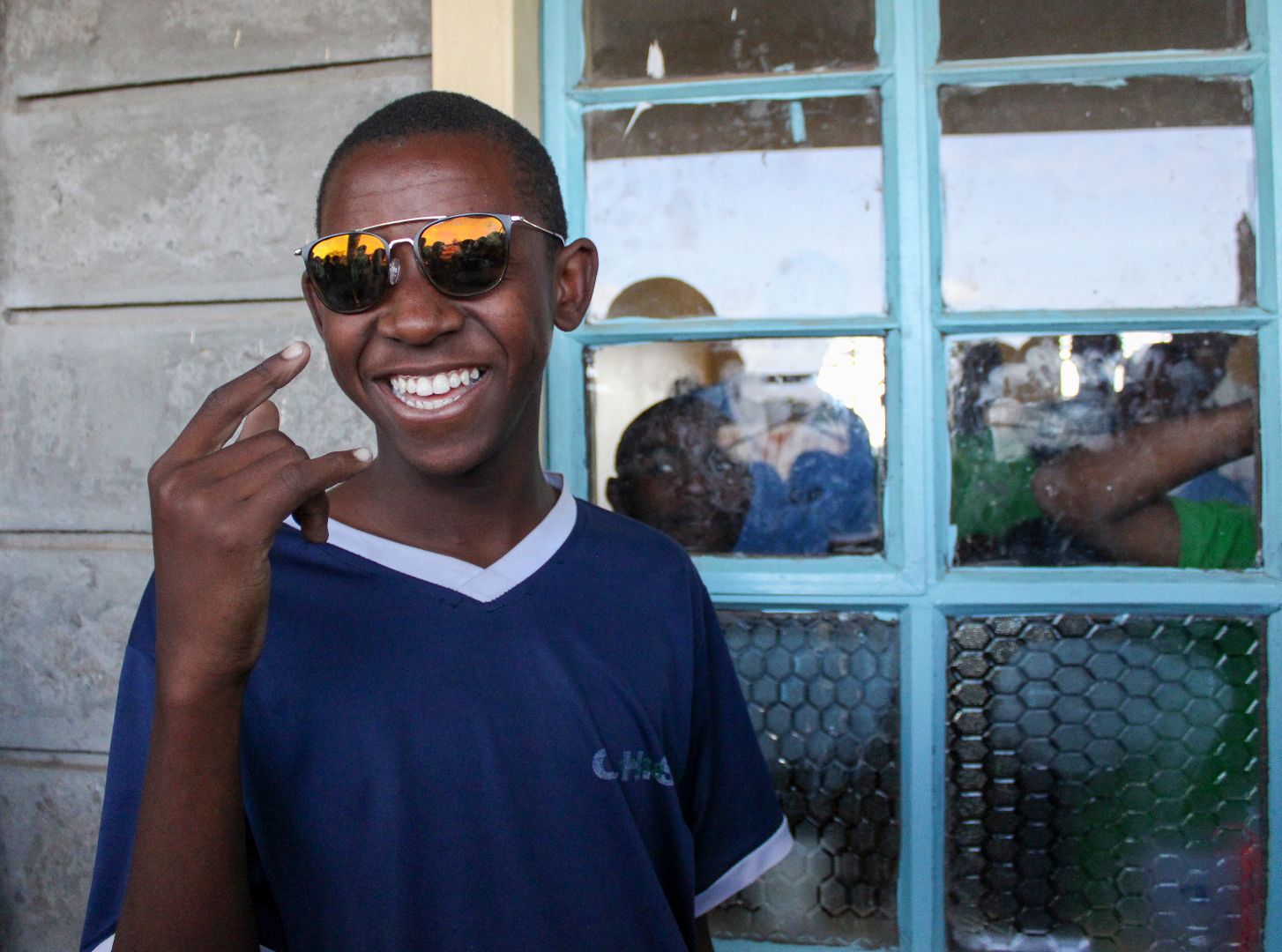 Kenyan man smiling with blue shirt and sunglass