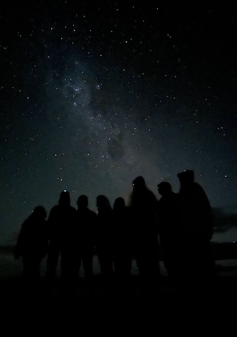 Night scene of group of students looking up at the stars