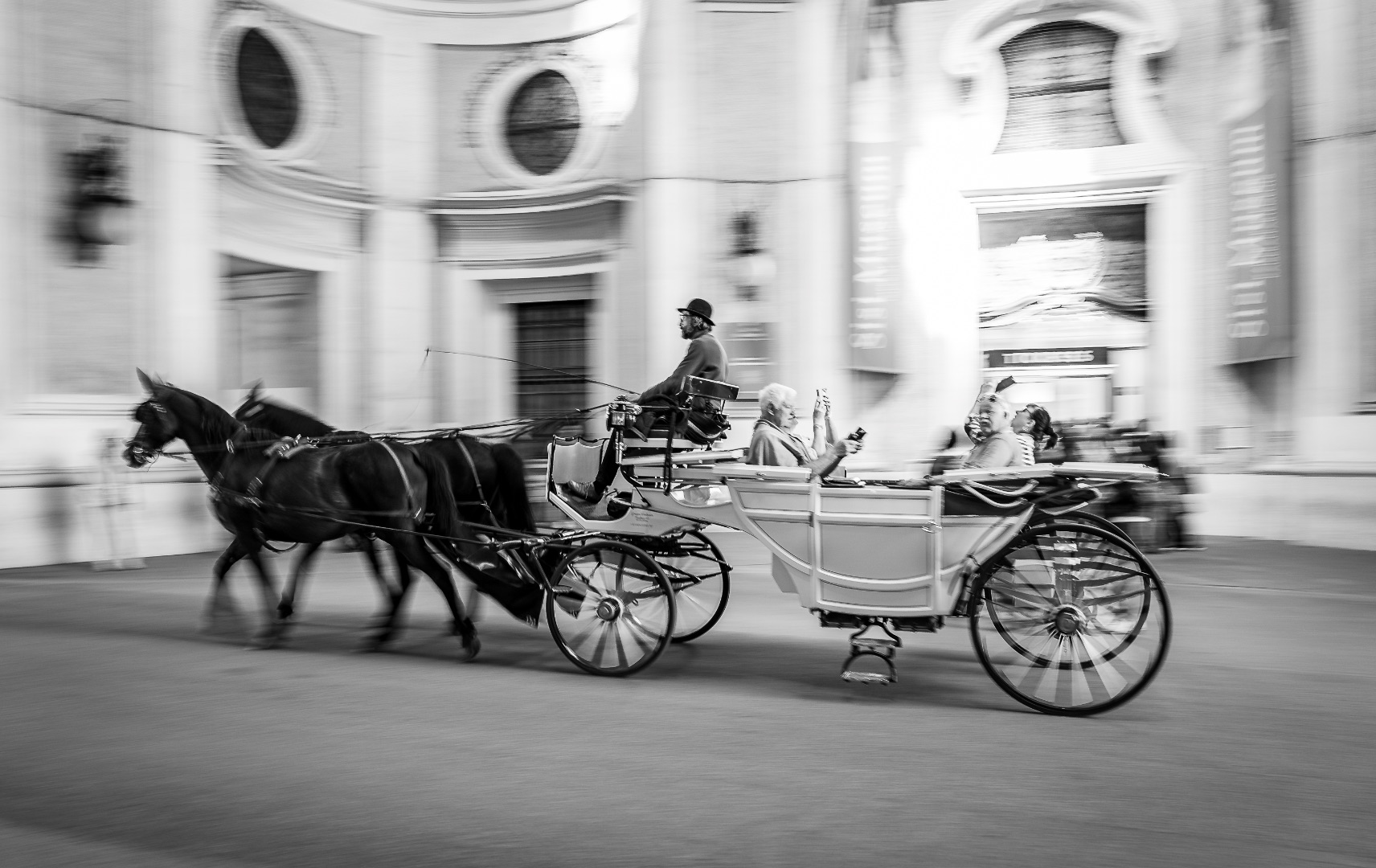 a horse-drawn carriage driving past an ornate building